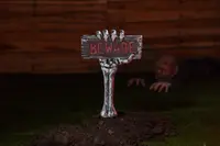 Skeletthand med skylt på spett