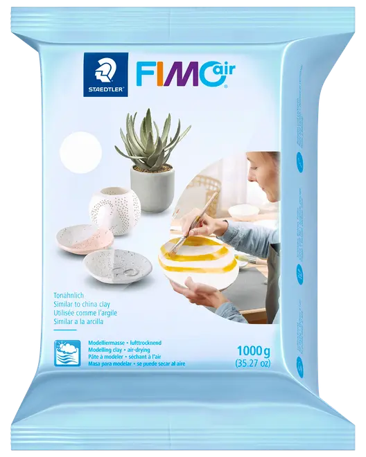 Staedtler FIMOair lufttørrende modellervoks, 1000g pakke. Velegnet til hobbyprojekter, ligner porcelænsler. Emballagen viser færdige skåle og urtepotter.