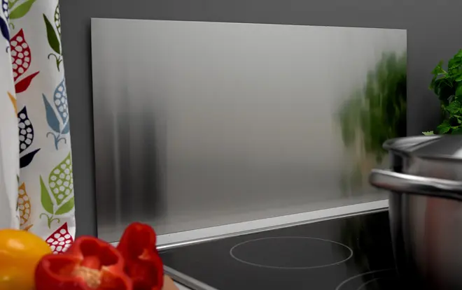 Rektangulär stänkskyddspanel i rostfritt stål, slät borstad yta, placeras bakom spisen för att skydda väggen mot stänk. Lätt att rengöra, modern design.