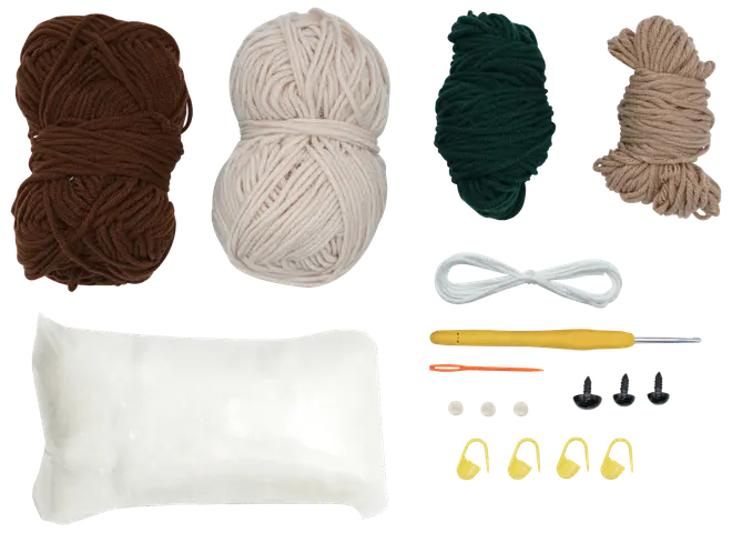 Pysselkit med brunt, creme, grönt och beige garn, stoppning, virknål, nål, maskmarkörer, säkerhetsögon och tråd—perfekt för amigurumi eller virkprojekt.