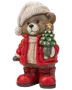 Festlig teddybjørn-figur med strikket hue og rød jakke, der holder et lille juletræ og har røde støvler.