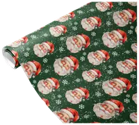 A roll of wrapping paper featuring a festive pattern of vintage-style Santa Claus faces wearing red hats, set against a dark green background with white snowflakes scattered throughout. The design has a classic, nostalgic holiday feel.