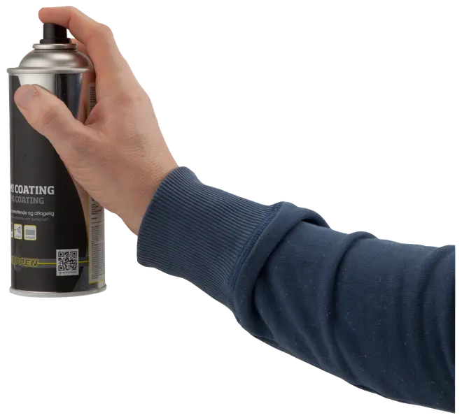 En person holder en sort og sølv spraydåse og trykker på dysen. Dåsen har produktinformation, ikoner og QR-kode på etiketten. Personen har en blå sweatshirt på.