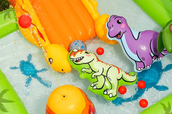 Oppusteligt børnepool-legetøj med en lille orange rutsjebane, dinosaurformede badedyr, vandsprøjt og farverige plastikkugler, ideel til udendørs vandleg og fantasifuld leg.