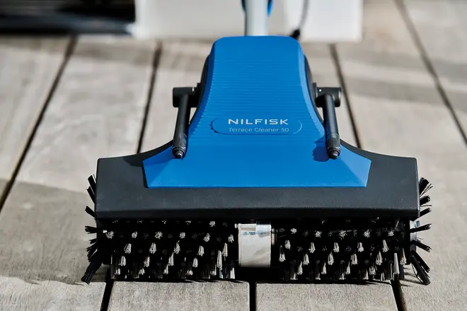 Nilfisk Terrace Cleaner 50 med blå og sort krop, solidt håndtag og roterende børster, designet til effektiv rengøring af udendørs overflader som terrasser og dæk.