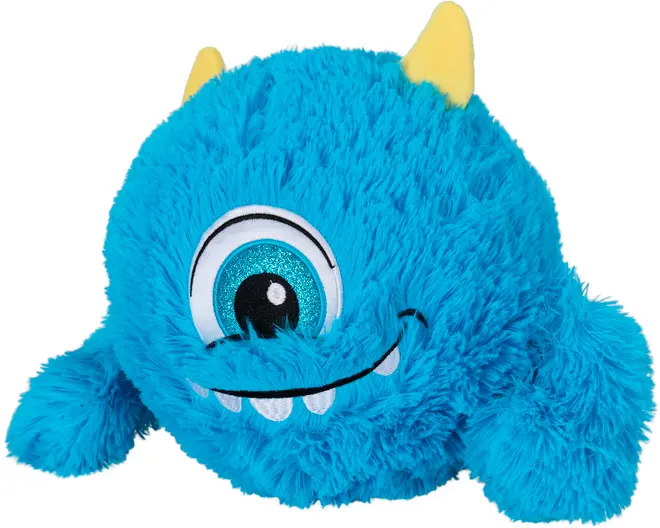 Blå plyssmonster-legetøj med ét stort glitrende øje, to gule horn, smilende mund med hvide tænder og blød, fluffy tekstur. Velegnet til børn og dekoration.