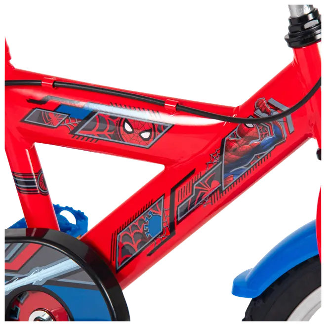 Rød og blå børnecykel med Spider-Man-grafik, sorte kabler og farverige figurklistermærker på stellet.