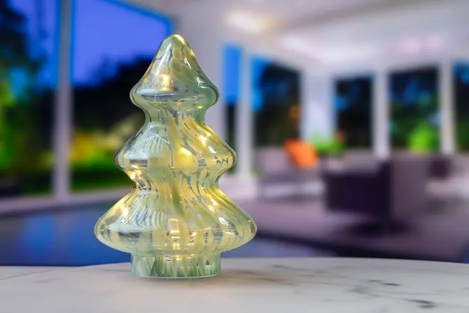 Glasprydnad formad som en julgran med inbyggda LED-lampor som ger ett varmt sken. Dekorativ bordsprydnad, klart glas med reflekterande mönster, perfekt för juldekoration.