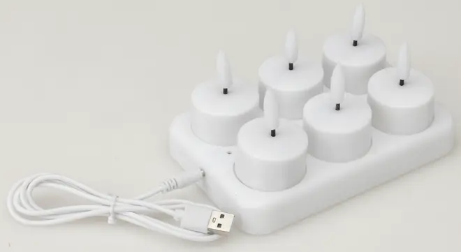 Sæt med seks hvide genopladelige LED fyrfadslys med flammeformede spidser på en opladningsbase. Inkluderer USB-opladerkabel. Perfekt til sikker, flammeløs stemningsbelysning.
