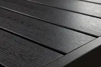 Närbild av svart utomhusbord med träådrad yta och ribbdesign, matt finish och robust rektangulär ram, perfekt för uteplats eller trädgård.