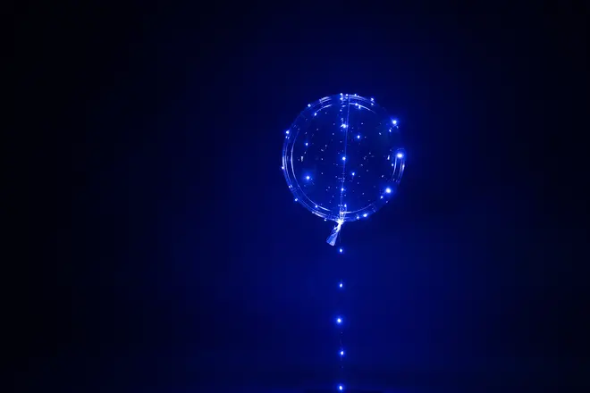 Transparent ballong med blå LED-ljusslinga inuti och längs snöret. Ger glödande effekt, perfekt för fester, dekorationer eller speciella tillfällen. Batteridriven, återanvändbar.