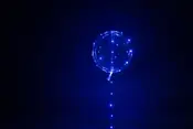 Transparent ballong med blå LED-ljusslinga inuti och längs snöret. Ger glödande effekt, perfekt för fester, dekorationer eller speciella tillfällen. Batteridriven, återanvändbar.