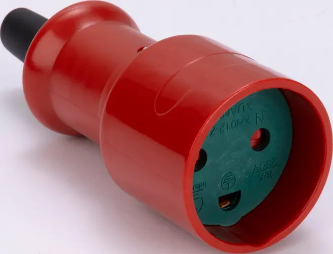 Rød industriel elkobling med cylindrisk корпус, grøn sokkelflade og sort kabelende.