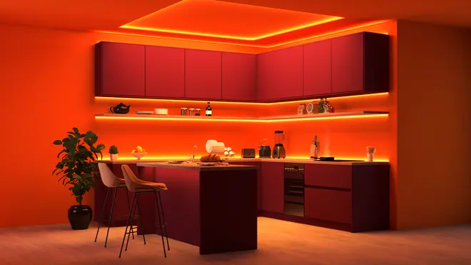 Moderne køkken med bordeaux skabe, orange LED-belysning, køkkenø med to barstole, indbyggede apparater, åbne hylder og en potteplante. Elegant, farverig indretning.