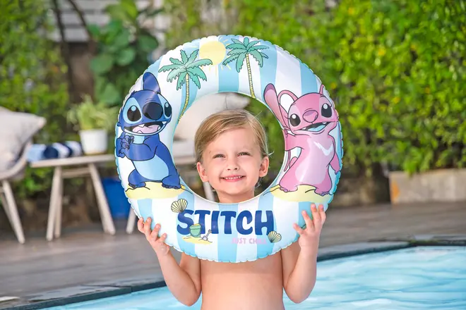 Oppustelig badering til børn med blå og lyserød Stitch-figur, palmetræer og teksten “STITCH” foran. Lavet af holdbar plastik, velegnet til brug i pool.