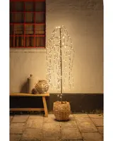 Konstgjord pilträd med hängande varmvita LED-lampor i en flätad korgkruka. Passar för dekorativ belysning inomhus eller utomhus, ger en mysig atmosfär.