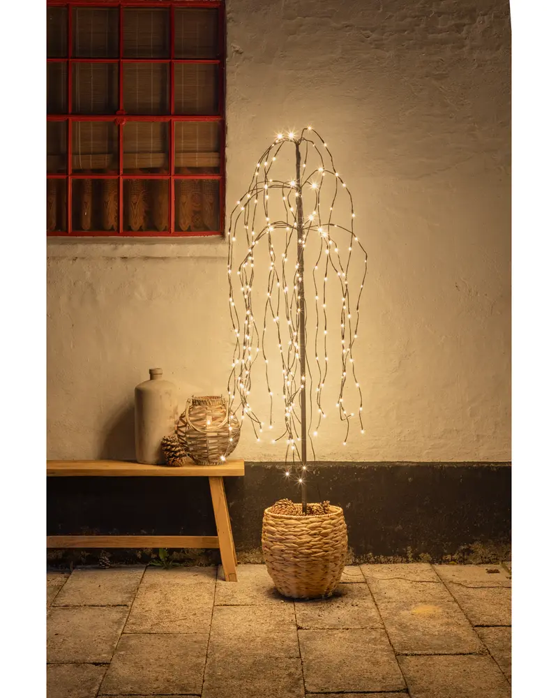 Konstgjord pilträd med hängande varmvita LED-lampor i en flätad korgkruka. Passar för dekorativ belysning inomhus eller utomhus, ger en mysig atmosfär.