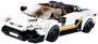 Vit LEGO-liknande racerbilsmodell med svarta detaljer, nummer 18-dekaler, tonad vindruta och två minifigurer inuti.