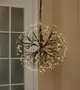 Hængende dekorativ lampe med sort grenlignende stel og varme hvide LED-spidser, der danner en rund mælkebøtte-lignende lysekrone.