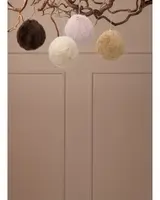 Fyra fluffiga bollar av fuskpäls i brunt, kräm, rosa och beige, med snöre för upphängning, perfekta som dekoration på träd eller i hemmet.