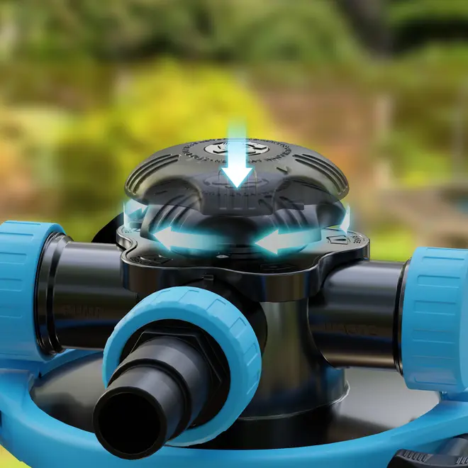 Nærbillede af sort og blå plastventil med flere slangetilslutninger og et centralt drejehåndtag til justering af flowretning, velegnet til have- eller poolvandsystemer.