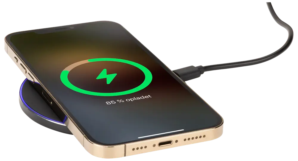 Guldfärgad smartphone på svart trådlös laddningsplatta, ansluten med USB-kabel. Skärmen visar laddningsstatus på 85%. Elegant design med rundade kanter och synlig laddningsport.