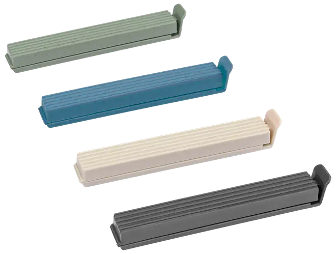 Fyra plastklämmor för påsar i grönt, blått, beige och grått. Varje klämma är rektangulär med räfflad yta och säker låsning för att försluta påsar.