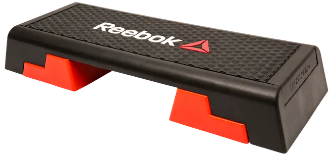 Reebok aerobic stepbænk med skridsikker sort overflade, røde justerbare fødder og hvidt logo. Velegnet til steptræning, kondition og styrketræning. Holdbar og let.