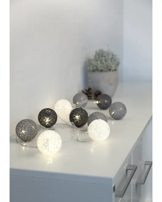 Ljusslinga med dekorativa LED-bollar i vitt, grått och svart. Bollarna har en texturerad yta och passar för mysig inomhusdekoration.