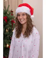 Vit långärmad pyjamasskjorta med röda hjärtan och polkagrisar, knäppning fram. Festlig design för jul. Modellen bär även en röd och vit tomteluva.