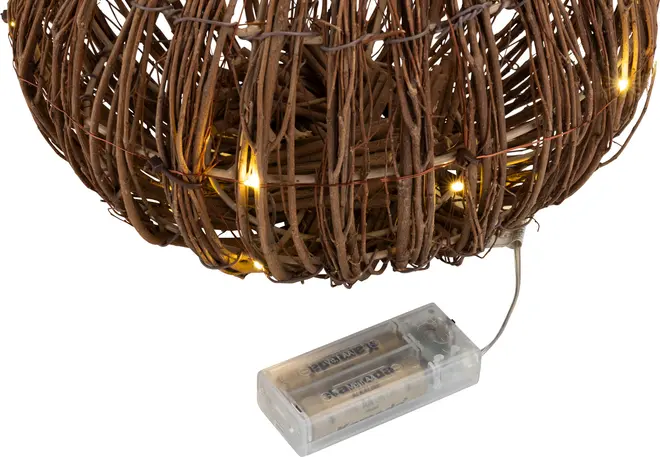 Brun flätad boll med inbyggda varmvita LED-ljusslingor, drivs av två AA-batterier i en genomskinlig batterilåda. Dekorativ, rustik design för inomhusbruk.