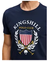 Mörkblå t-shirt med texten "Kingshill Polo Club", sköld med röda och vita ränder, lagerkrans, korsade poloklubbor och hjälm. Grundad 1917.