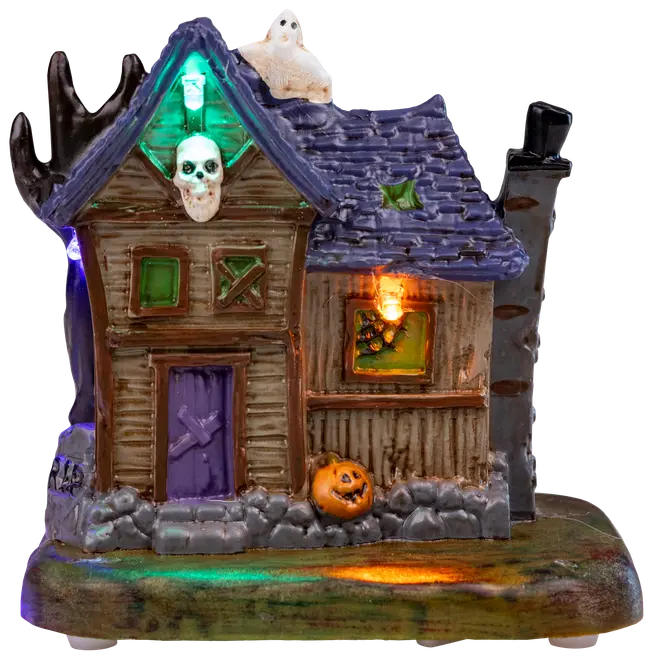 Keramikhus i spökstil med lila tak, brädade fönster, färgade lampor, ett spöke på taket och en pumpa vid basen. Perfekt för Halloween.