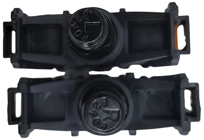 Par svarta plastaxlar för inlines med synliga skruvhuvuden, rektangulära fästen i ändarna och cylindrisk mittdel för hjulmontering.