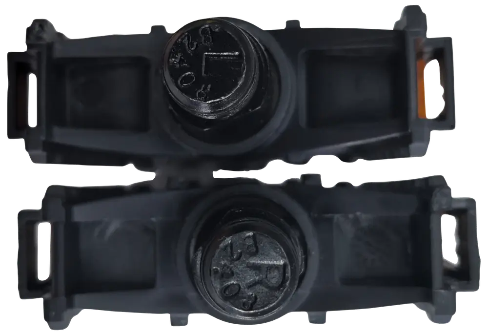 Sæt sorte plastikhjulaksler til rulleskøjter med synlige skruehoveder, rektangulære monteringsbeslag i hver ende og cylindrisk midtersektion til hjulmontering.