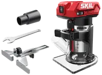 SKIL sladdlös borstlös kompaktfräs med röd och svart kropp, genomskinlig bas, djupjustering, strömbrytare samt tillbehör: kantlinjal, nyckel och dammutsugsadapter.