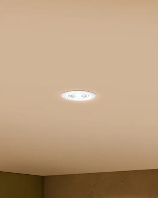 Rund indbygget loftslampe med hvid kant, udsender klart hvidt lys. Moderne, minimalistisk design, der passer til forskellige indendørs rum. Flad med loftet for et rent udtryk.