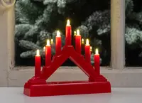 A red, triangular candle holder with seven electric candles arranged in a stepped pattern. Each candle has a small, flame-shaped bulb that emits a warm yellow light. The base is wide and sturdy, providing stability for display on a flat surface. The design is simple and festive, suitable for holiday decoration.
