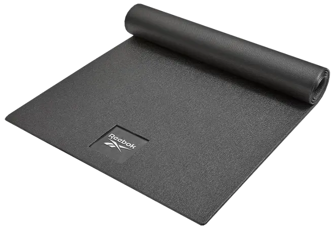 Sort Reebok træningsmåtte med tekstureret overflade, delvist rullet op. Har Reebok-logo i hjørnet. Velegnet til yoga, pilates og fitness. Let og bærbar.