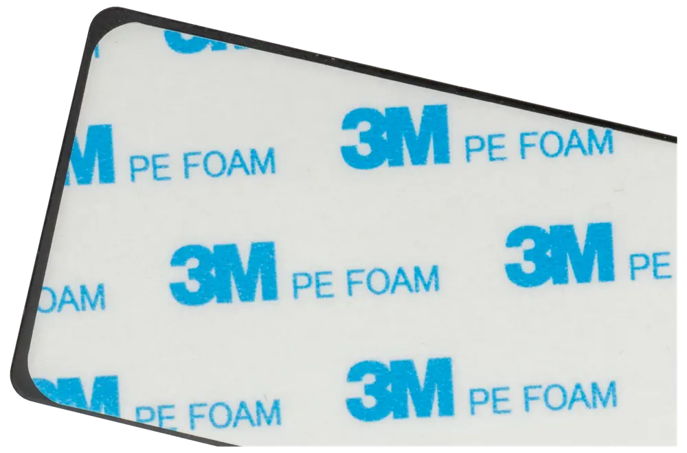 Rektangulär självhäftande dyna med vit yta, blå "3M PE FOAM"-text och svart kant. Används för montering eller fastsättning, dubbelsidig skumtejp.