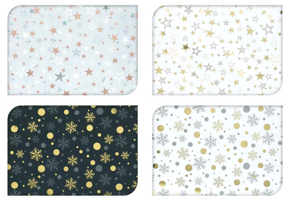 Fyra rektangulära bordsunderlägg med festliga stjärn- och snöflingemönster i guld, silver och brons på vita och svarta bakgrunder. Tillverkade av slitstarkt, lättskött material.