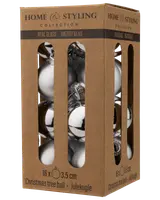 Förpackning med 16 silverfärgade julgranskulor i glas, varje 3,5 cm i diameter, i brun kartong med fönster för enkel visning och förvaring.