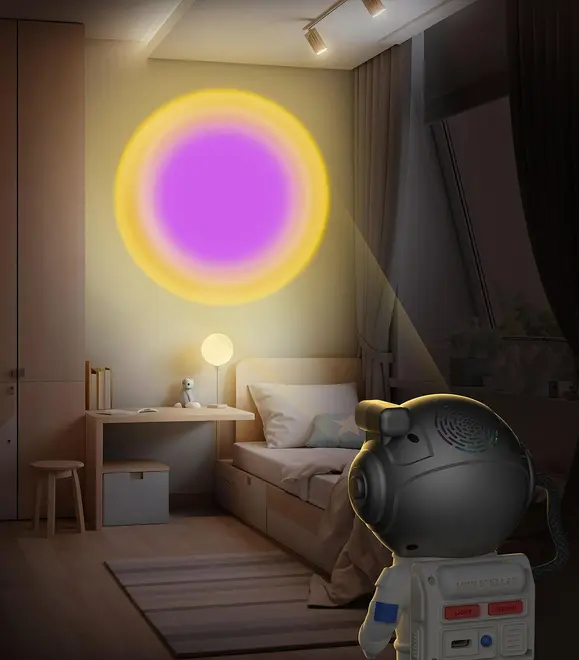 Projektorlampe formet som astronaut til børn, kaster et farverigt lilla og gult cirkulært lysmønster på væggen. Perfekt til soveværelser eller legerum, skaber hyggelig stemning.