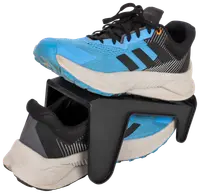 Blå og sorte sportssko placeret på en sort plastik sko-organisator, som holder én sko ovenover den anden for at spare plads og holde skoene organiseret.