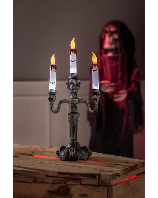 Gotisk kandelaber med tre LED-ljus, dödskalle- och fladdermusdetaljer samt fejkblod. Perfekt för Halloween eller skräckdekoration. Tillverkad i mörkt material.