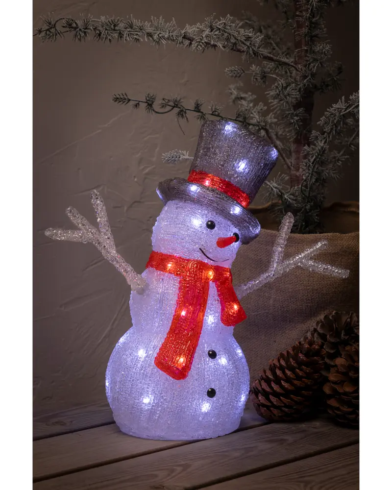 Upplyst snögubbe med svart hög hatt, röd halsduk, kvistarmar och morotsnäsa. Tillverkad av klar akryl med inbyggda LED-lampor för festlig dekoration.