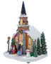 Snedækket julekirke med højt spir, oplyste vinduer, farverige lys, figurer, snemandsdekoration, grantræer og festlig krans.