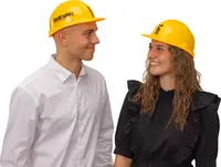 Klargul skyddshjälm med justerbart band och "harald nyborg"-logotyp. Tillverkad i slitstark plast, passar bygg- eller industribruk. Visas på vuxna för storleksreferens.