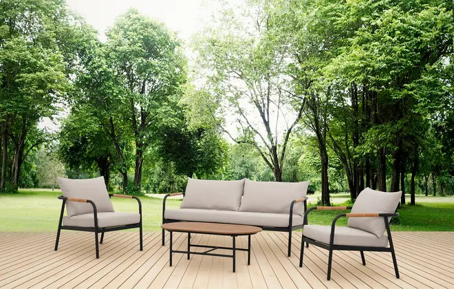 Udendørs loungesæt med to lænestole, en trepersoners sofa og et ovalt sofabord. Sorte metalstel, beige hynder og træarmlæn på træterrasse.