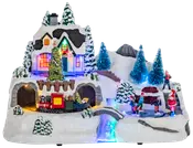 Belyst julbydekoration med snötäckt hus, julgran, rörligt tåg, skridskoåkare, tomtefigur och färgglada LED-lampor. Detaljerad vinterscen och festliga inslag.